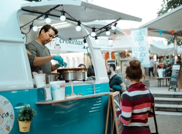 Man serving crepe from blue and white food truck_Photo by Arturo Rey on Unsplash