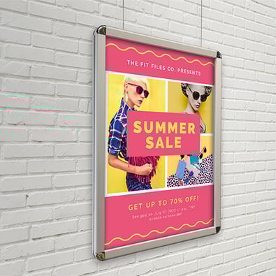 A pink and yellow large format print design, displayed on a white brick wall.