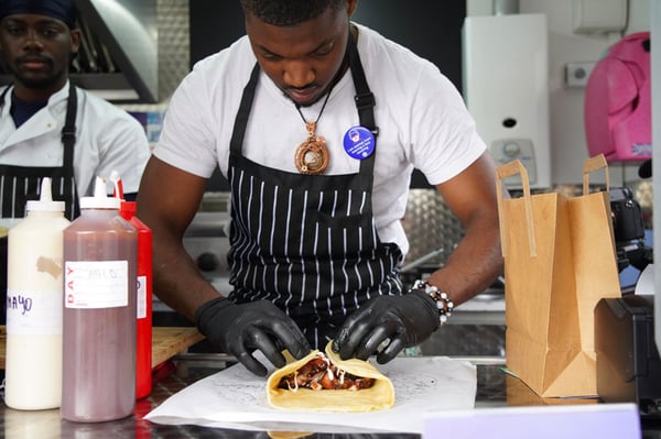 Investing in a food truck - chef preparing wrap on food truck