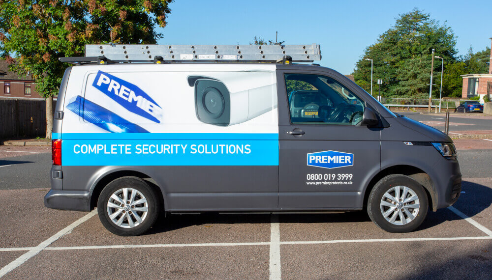 The Premier Alarms van wrap, with blue details and the message 'complete security solutions'.