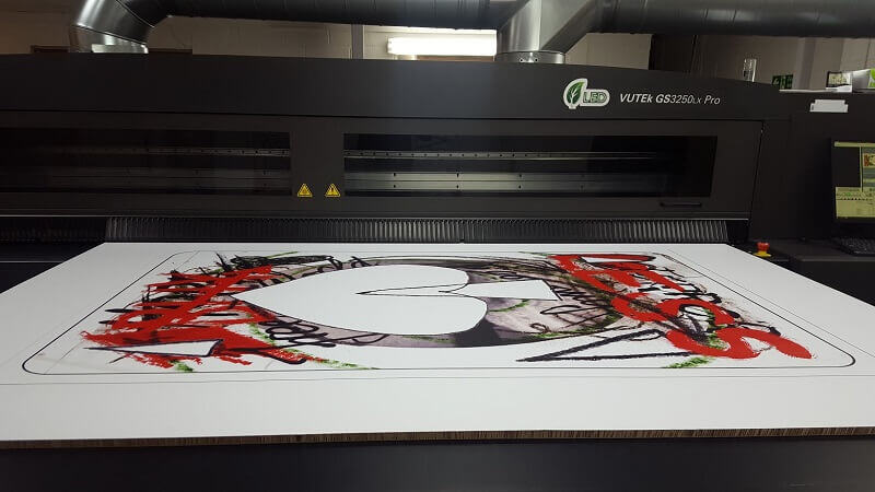 A large format print of a playing card, coming out of a printer, for Vivienne Westwood