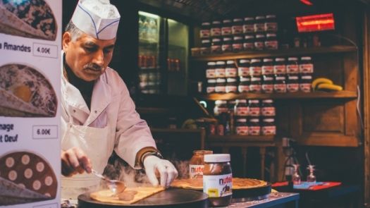 Man preparing crepes in a food truck kitchen