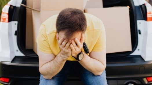 Vehicle wrapping mistakes - a man sits in the back of his van with his head in his hands