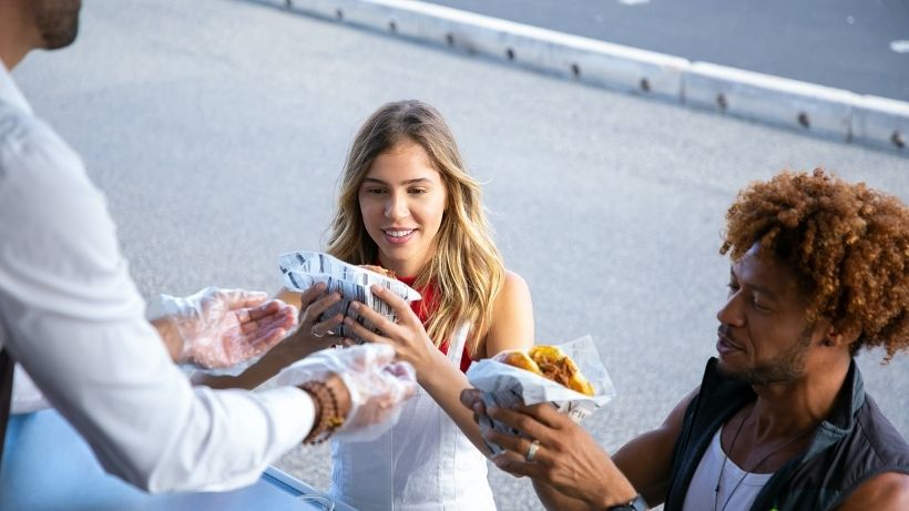 Investing in a food truck - man serving customers with food