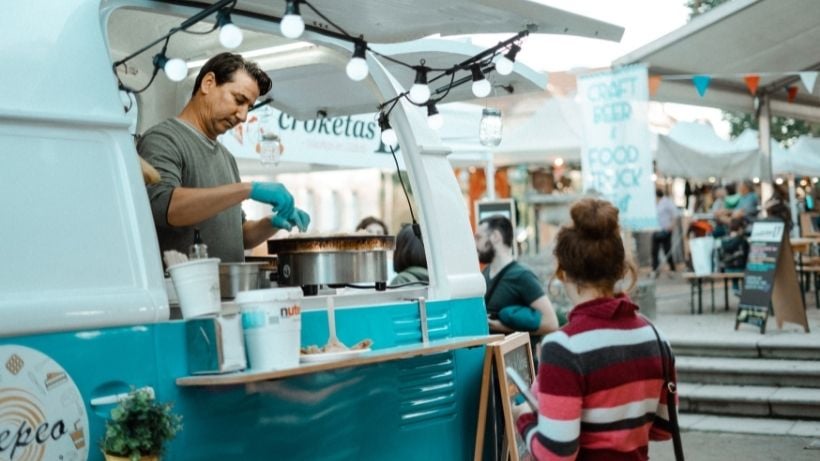 Man serving a customer from his food truck - how to finance a food truck